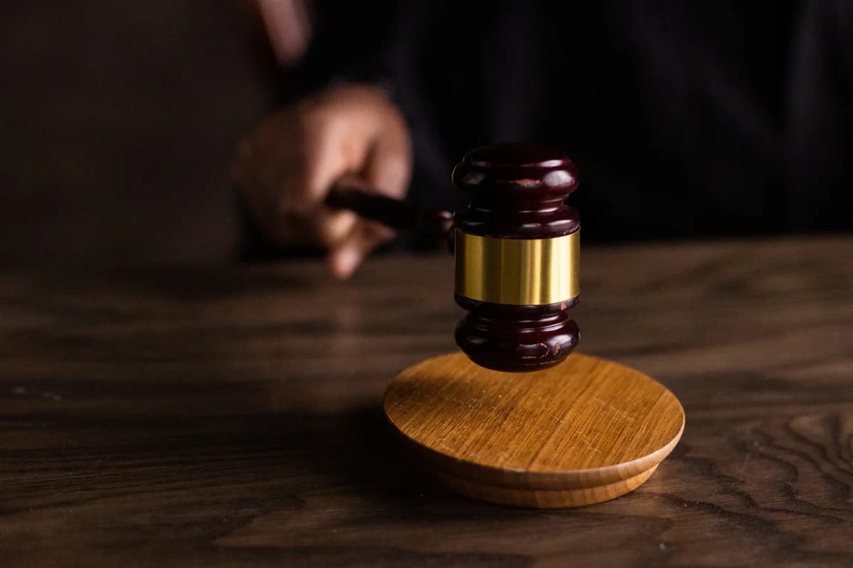 Judge's gavel striking sound block on wooden table