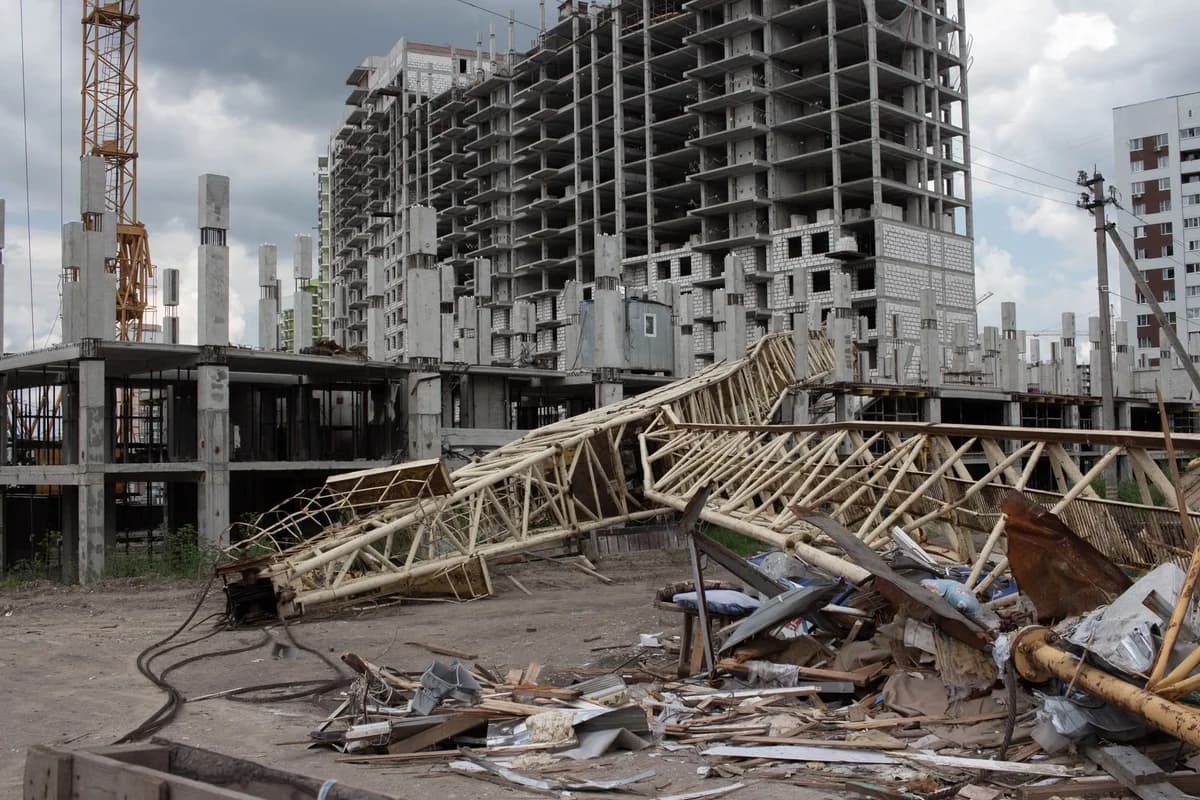 Collapsed crane at construction site with unfinished buildings